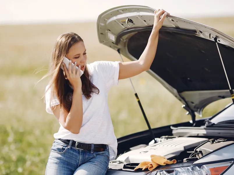 Girl with broken down car on the side of the road.