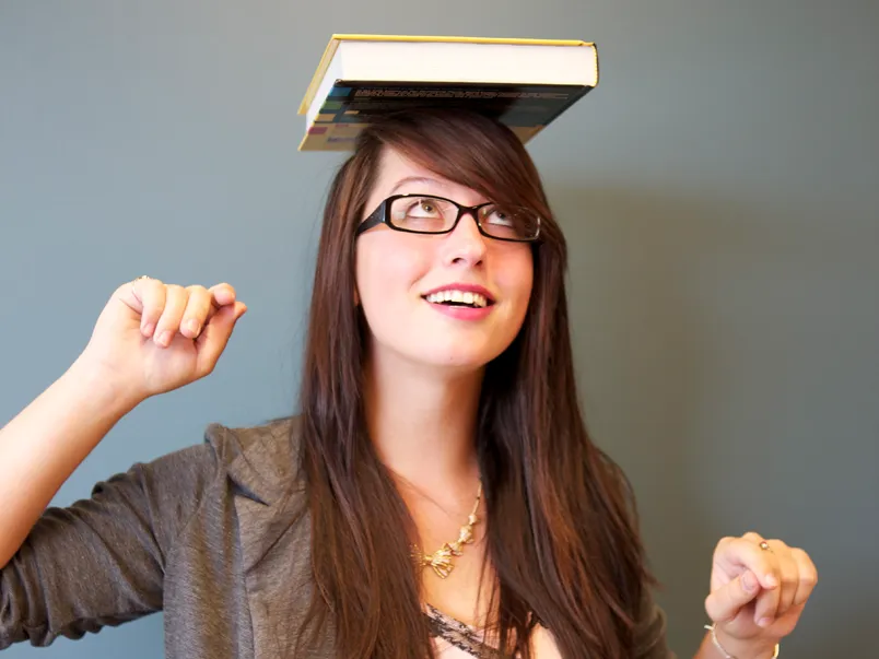 Student balancing textbooks on her head.