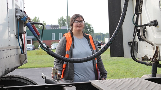 Female CDL Student checks connections on the truck