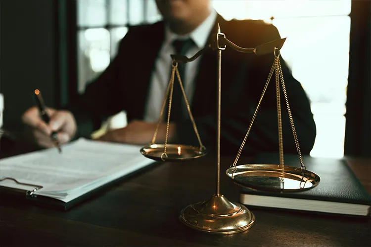 man sitting behind legal scale at desk
