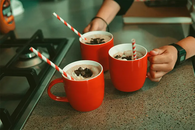 three red mugs filled with hot cocoa