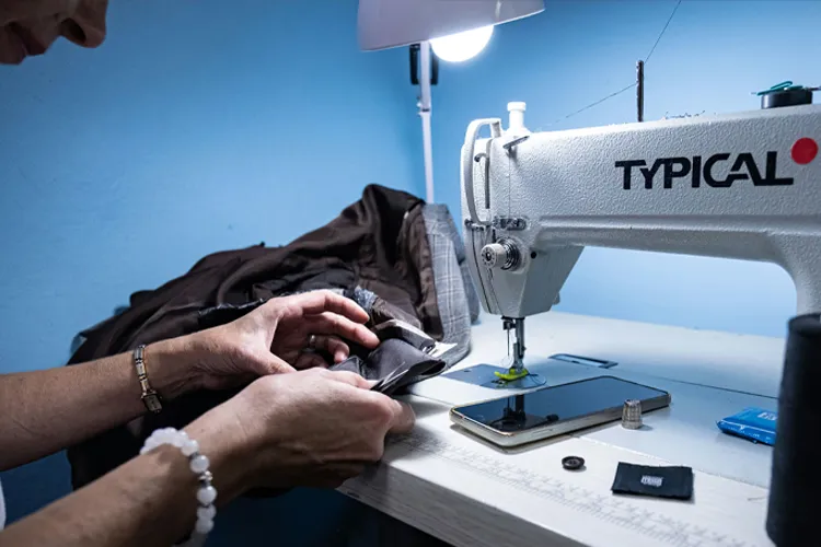Person sewing clothes on a sewing machine.
