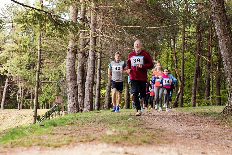 Group of people running on a wooded trail.