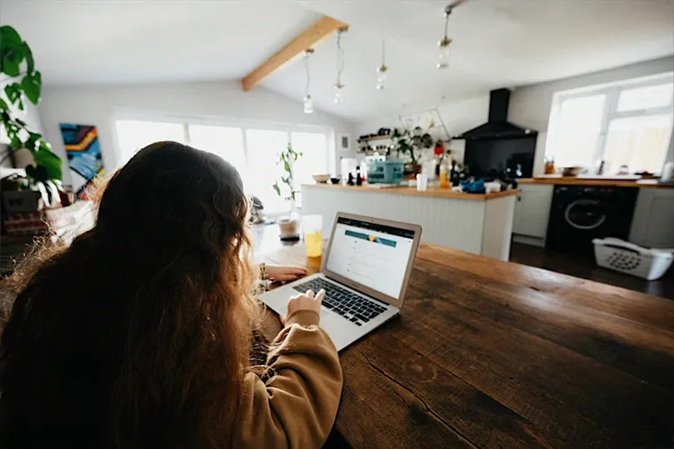 Teen girl typing on laptop computer