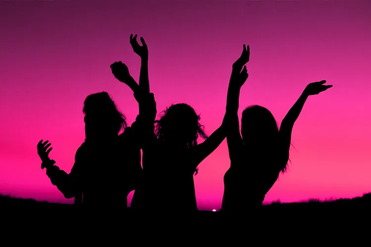 Silhouette of women in front of sunset.