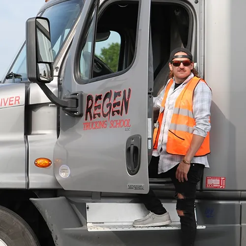 Student stands near CDL training truck.