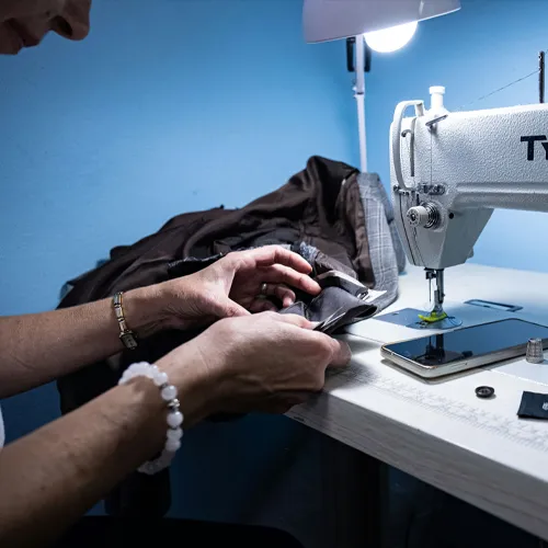 Person sewing clothes on a sewing machine.