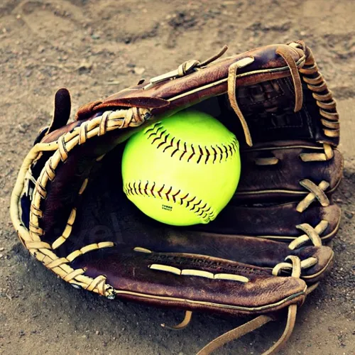 Softball in mitt on dirt